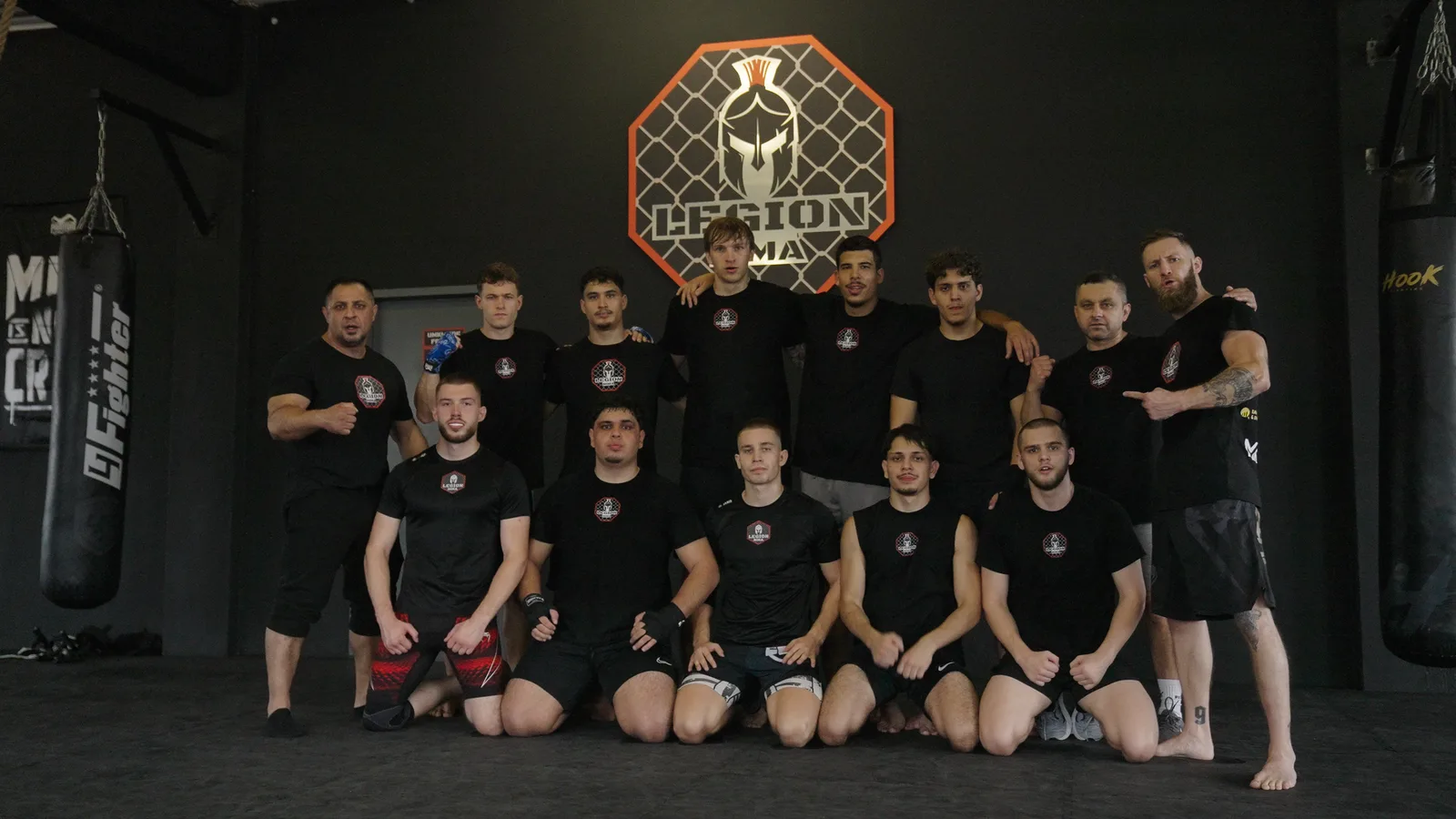 Das Team von Legion MMA vor dem Vereinslogo