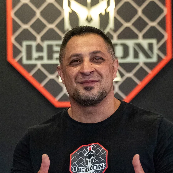 Arton Kasumaj, Striking-Coach und Krav-Maga-Instructor bei Legion MMA, vor dem Vereinslogo